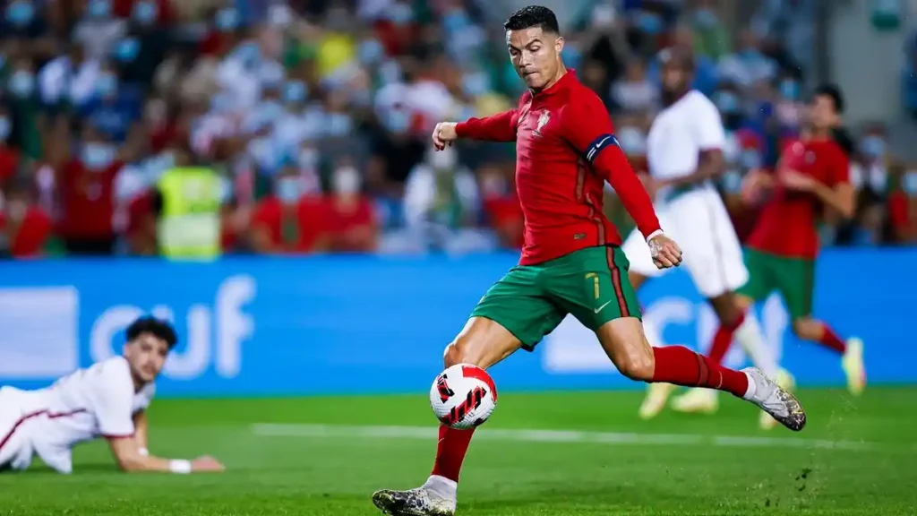 Action shot of Portugal's Cristiano Ronaldo facing off against Iran on the field.