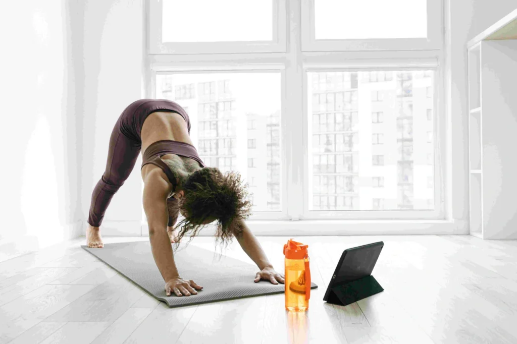 A woman performing yoga poses by a window.