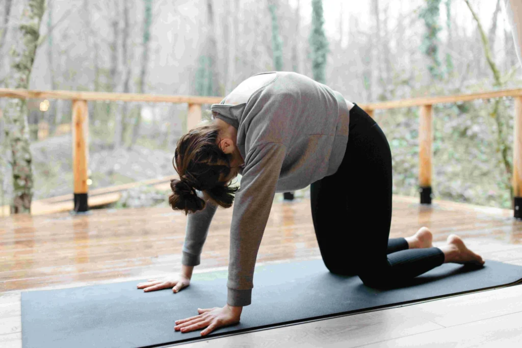 Woman in yoga pose on mat.