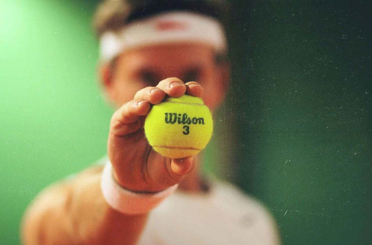 man with tennis ball in hand